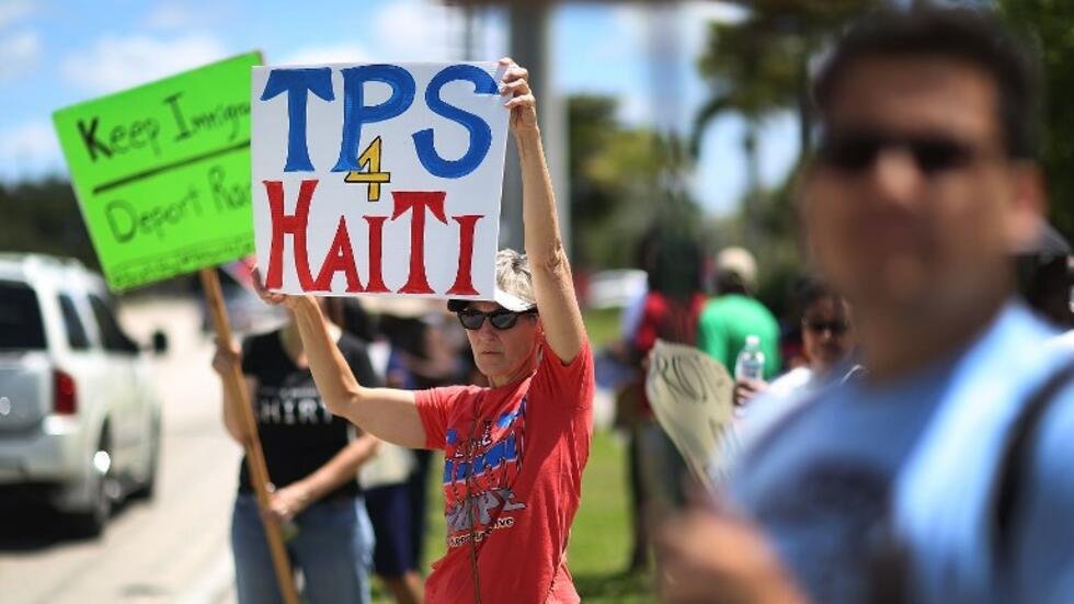 Manifestation contre la fin du TPS pour les Haïtiens aux États-Unis, avec des pancartes appelant à la compassion et à la protection.