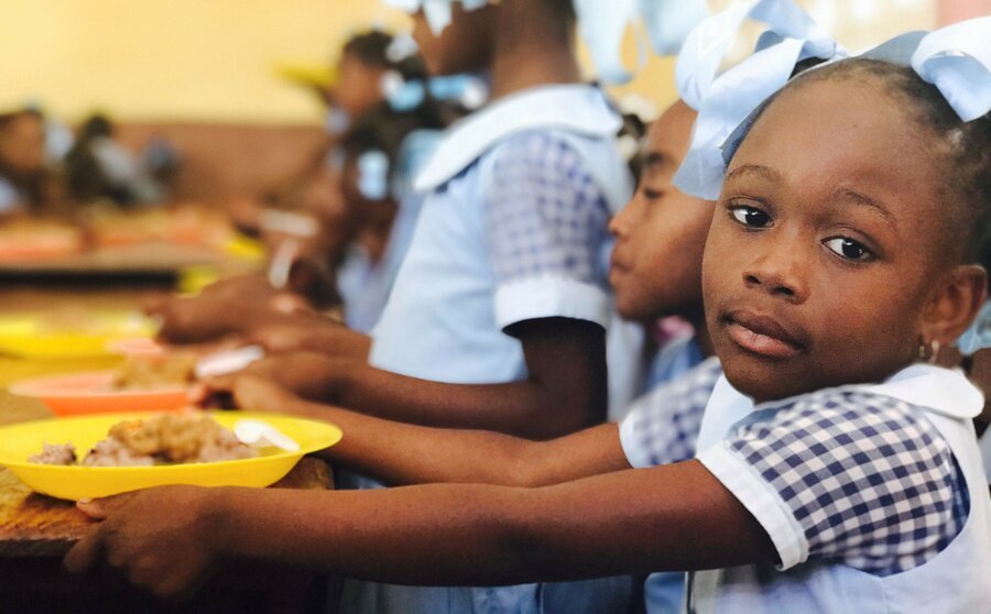 Cantine scolaire en Haïti :Des enfants mangent en classe grâce au PAM, une suspension menaçant plus de 100 000 élèves faute de moyens.