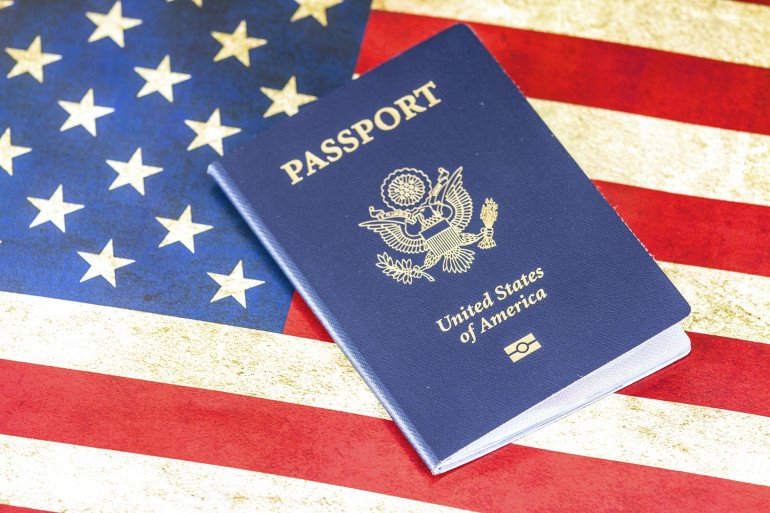 Passeport américain posé sur un drapeau des États-Unis, symbole menacé par le décret de Trump contre le droit du sol
