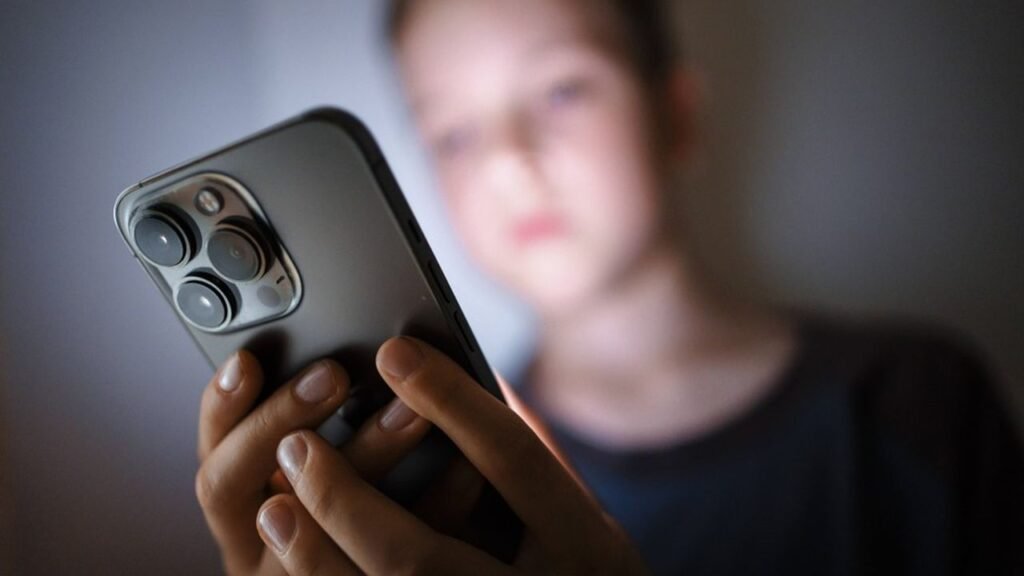 Adolescent telephone en main en utilisant OpenIA ,débat sur la responsabilité d’OpenAI.